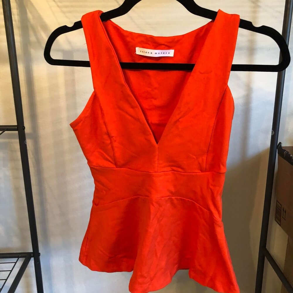 Very good condition orange Susana Monaco peplum top, size XS.